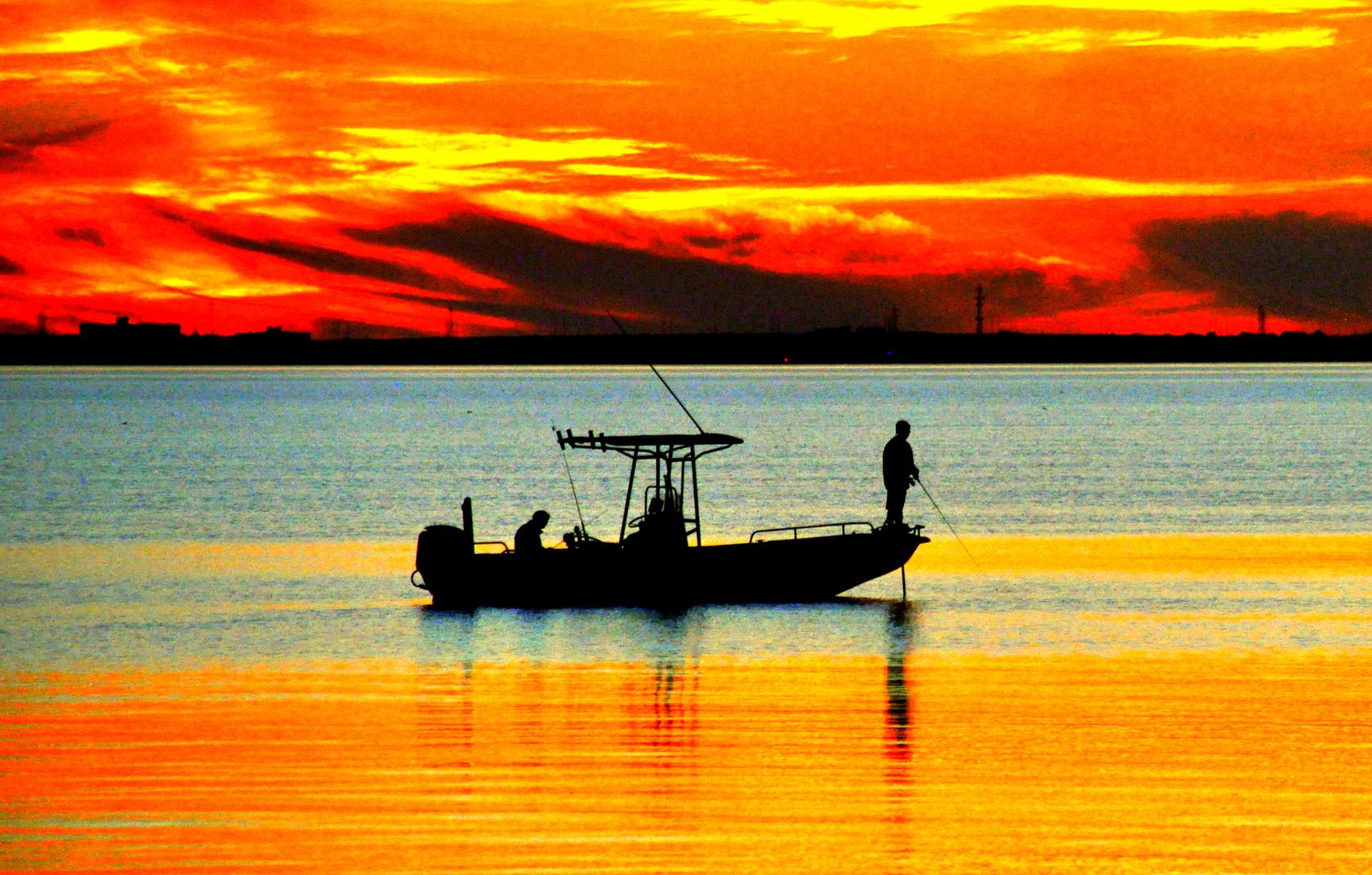 Silhouette of center console fishing boat at sunset in florida
